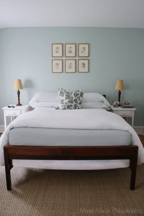 a white bed sitting in a bedroom next to two lamps