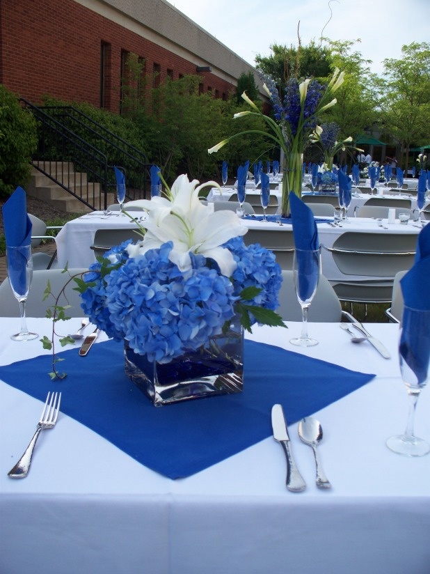 a blue and white centerpiece on a table with silverware