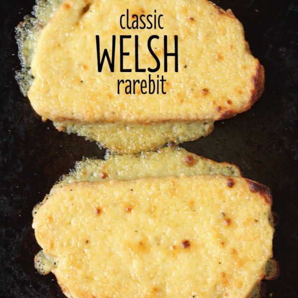 two pieces of bread sitting on top of a black surface with the words classic welsh rarebit