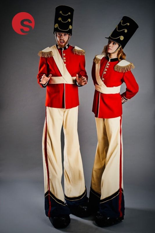 two people dressed in red and white uniforms standing next to each other with their hands on their hipss