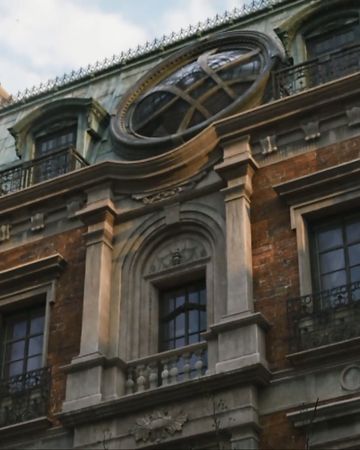 an old building with a large clock on it's face and balconies