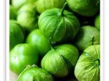 some green peppers sitting on top of a wooden table