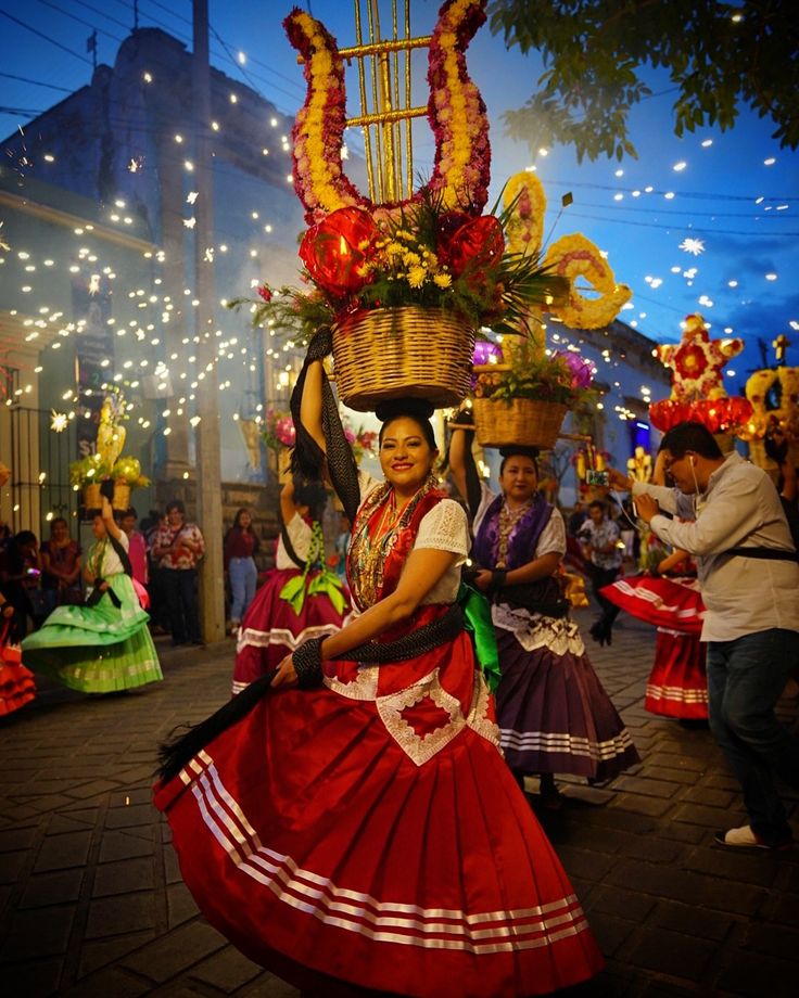 a woman in a red and white dress carrying a basket on her head while dancing