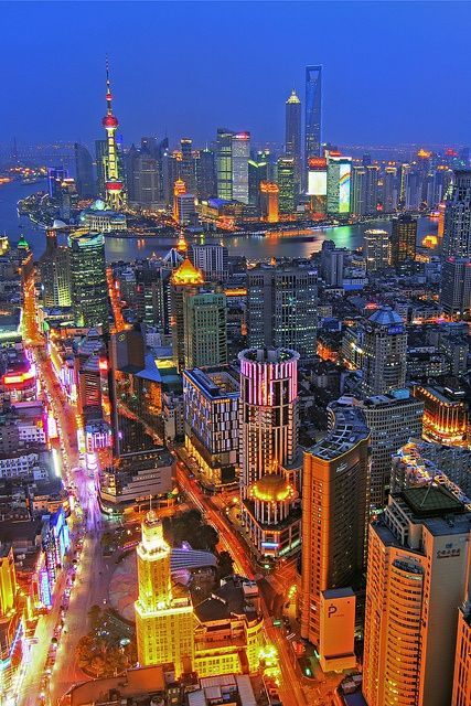 an aerial view of a city at night with lots of tall buildings and skyscrapers