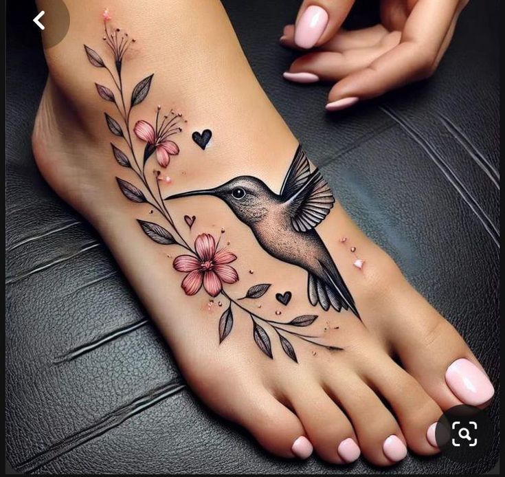 a woman's foot with a humming bird and flowers on it