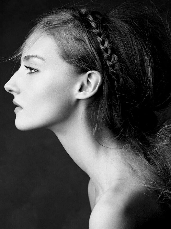 a black and white photo of a woman with her hair in a pony tail braid