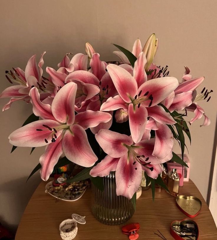 a vase filled with pink flowers sitting on top of a table next to other items