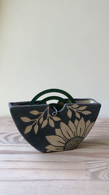 a black and white flowered bag sitting on top of a wooden table