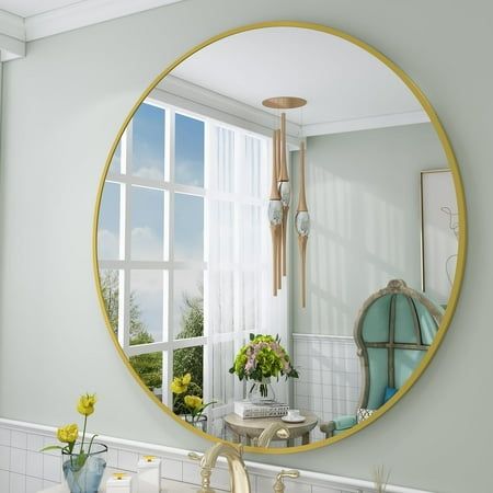 a bathroom with a round mirror above the sink