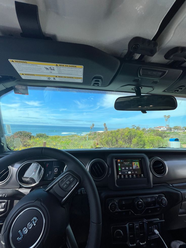 the interior of a vehicle with an ocean view in the background and blue sky