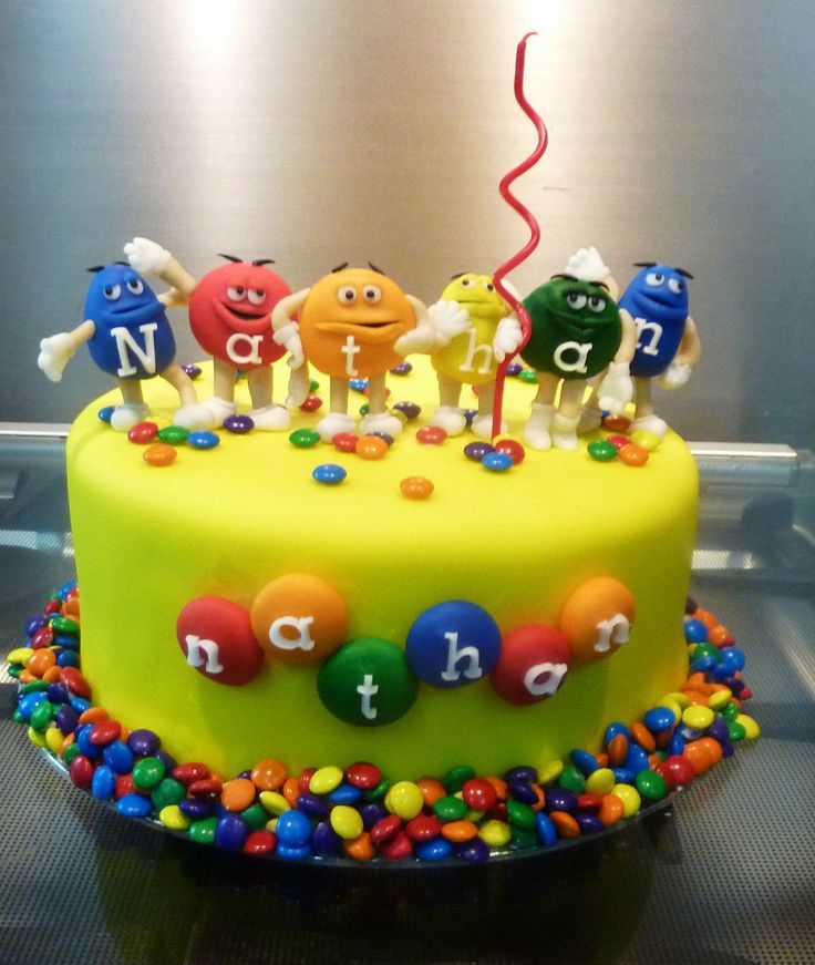 a birthday cake decorated with colorful candies and letters