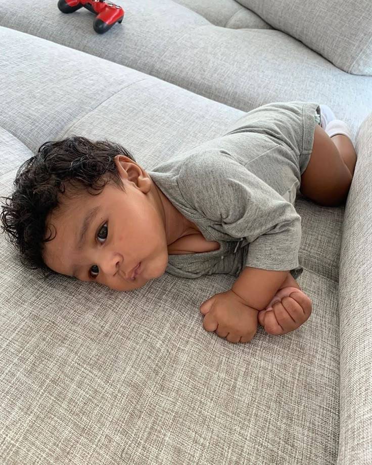 a small child laying on top of a couch