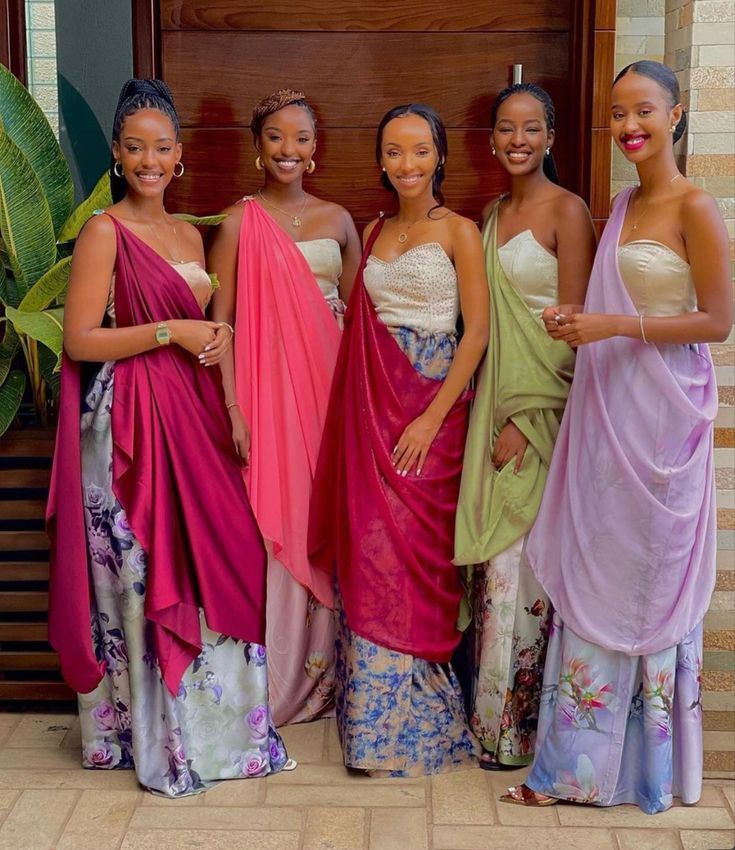 four women in dresses standing next to each other