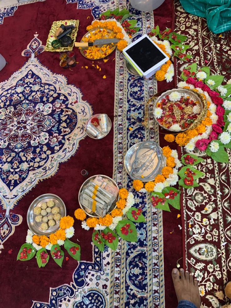 a person sitting at a table with food and flowers on the floor next to it