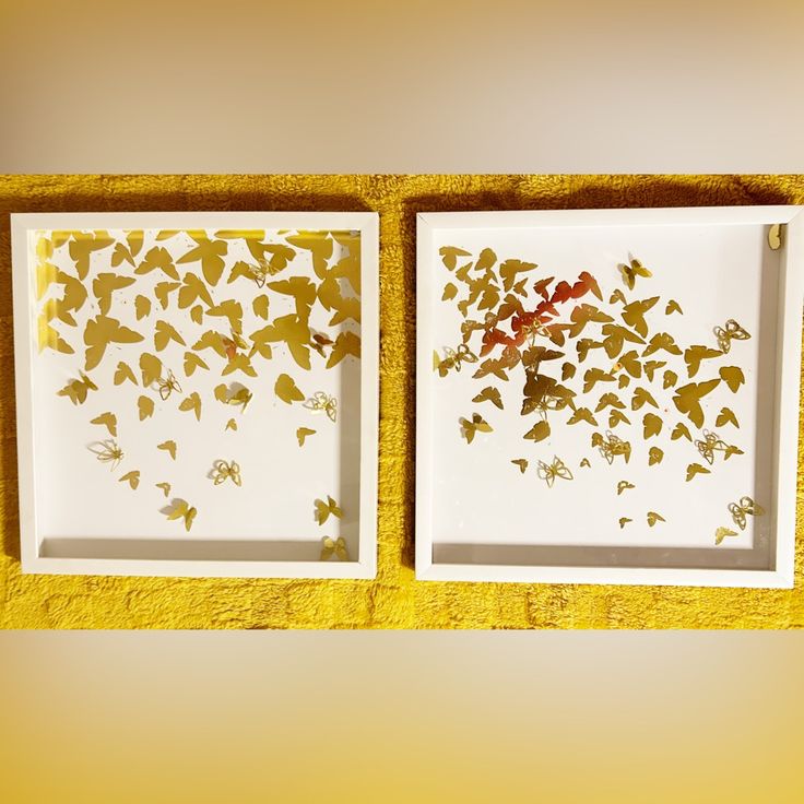 two white plates with gold foiled butterflies in them on a yellow towel next to each other