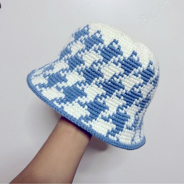 a knitted blue and white hat on someone's hand, with the pattern