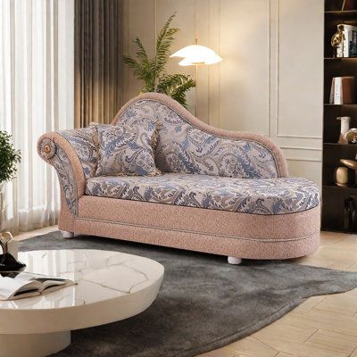 a living room with a couch, table and bookshelf on the wall behind it