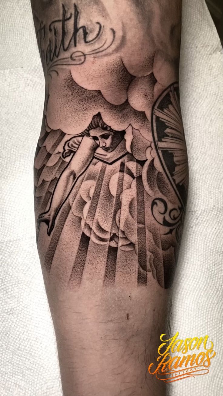 a man's leg with a tattoo on it and an angel above the clouds