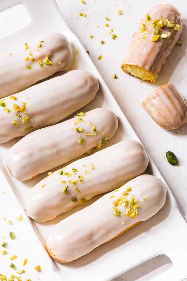 four glazed doughnuts in a white tray with sprinkles