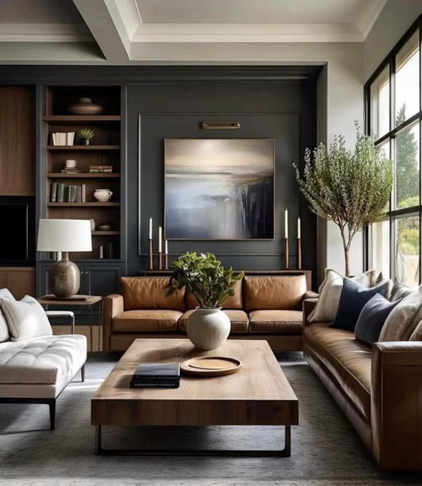 a living room filled with lots of furniture and large windows in front of the wall