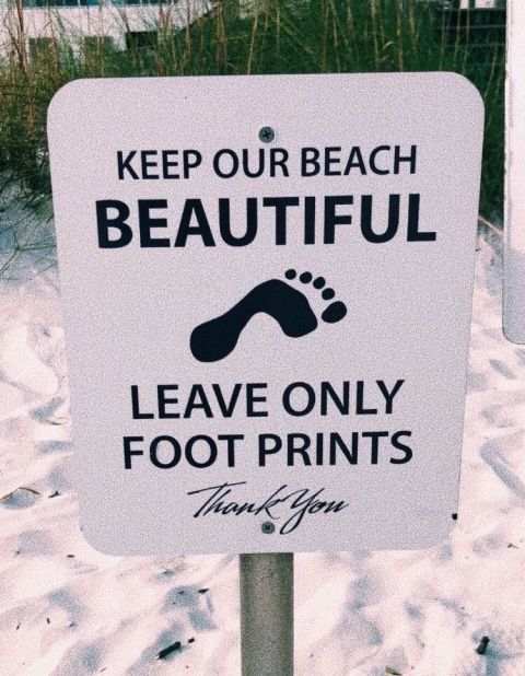 a white sign that says keep our beach beautiful leave only foot prints