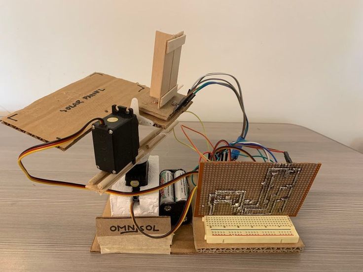 an electronic device sitting on top of a wooden table next to wires and other electronics