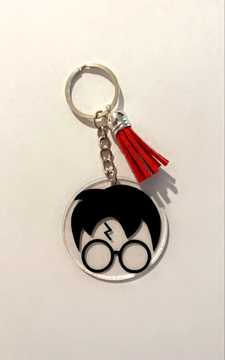 a harry potter keychain with glasses and a tassel hanging from it's side