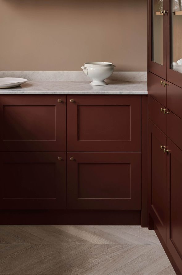 a white bowl sitting on top of a kitchen counter next to a wooden cabinet door