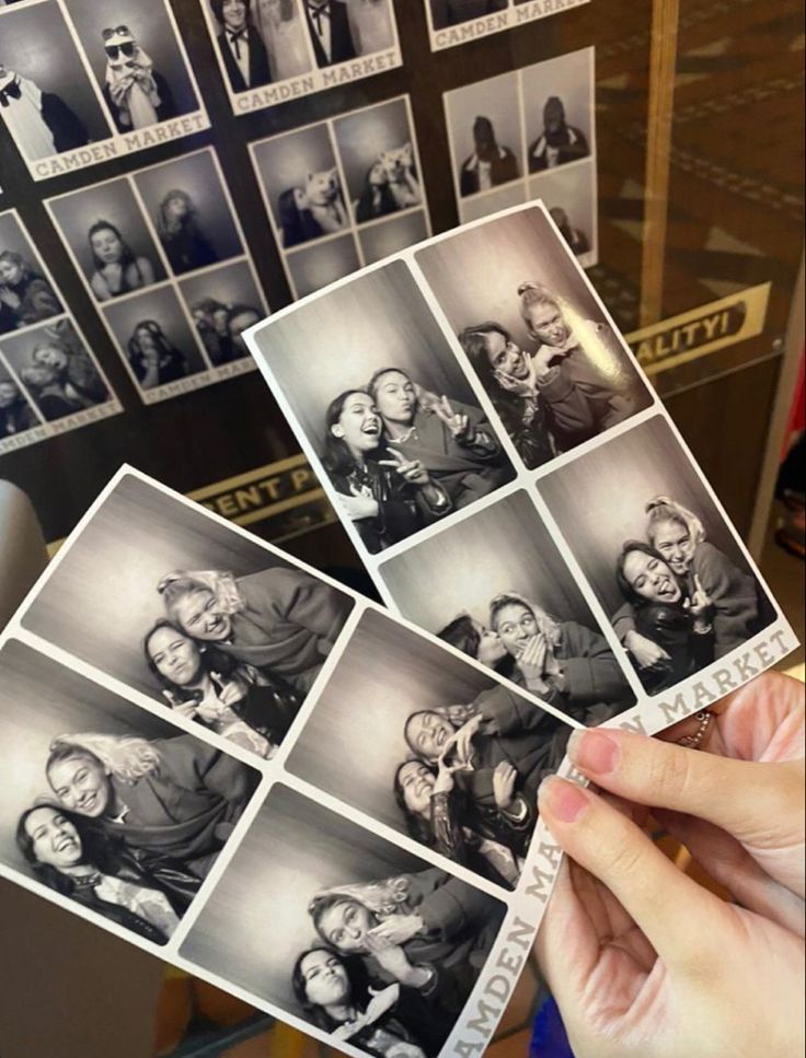 a person holding up some old photos in front of them