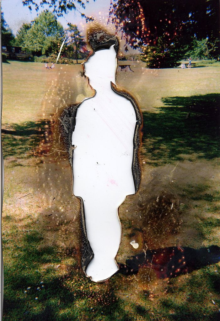 a man standing in the grass with his back to the camera