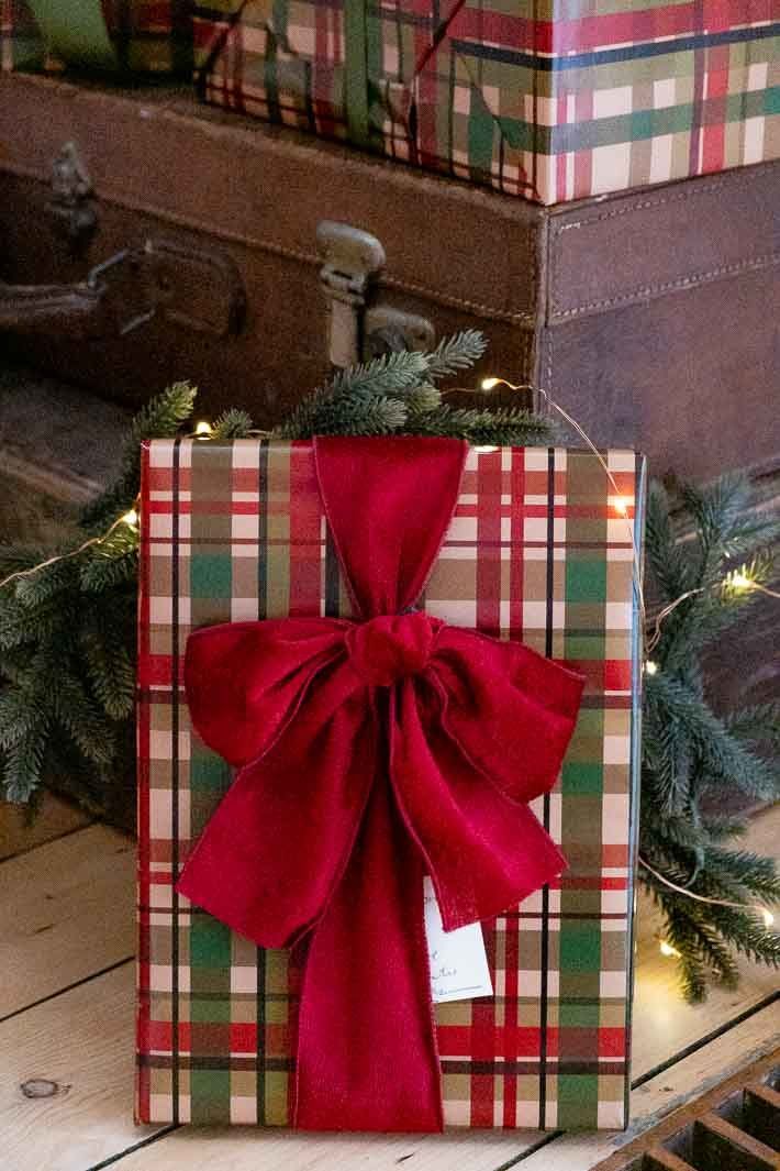 a present wrapped in plaid paper with a red bow