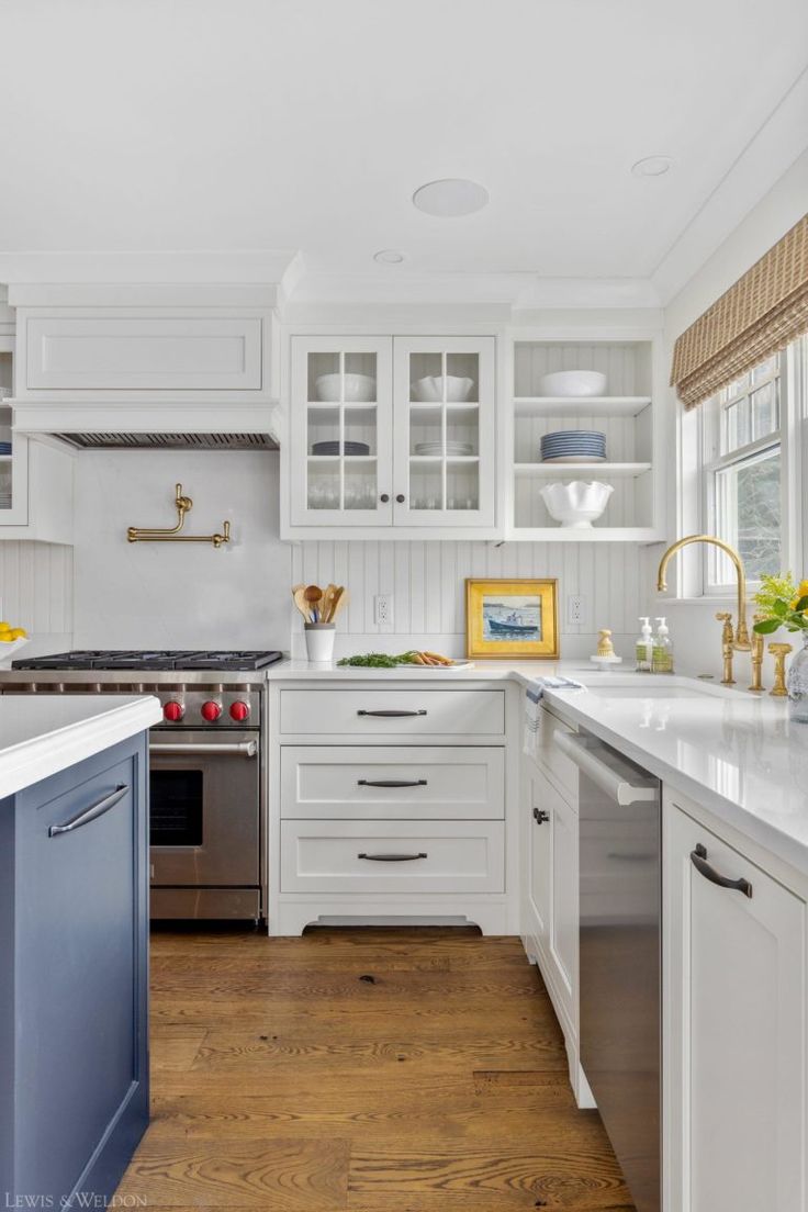 a kitchen with white cabinets and wood floors is featured in the magazine lewis & wedon