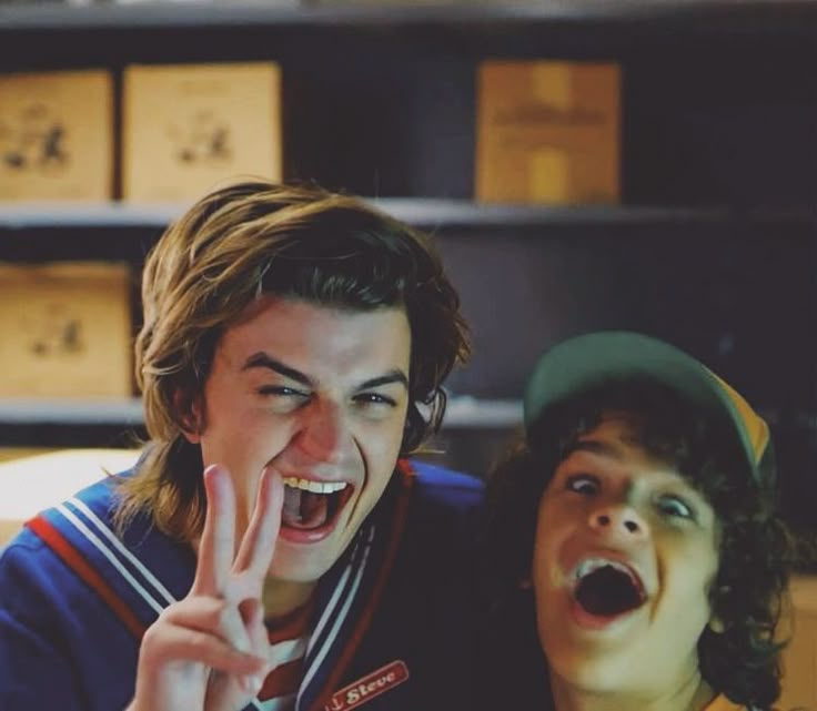 two young men making the peace sign with their hands