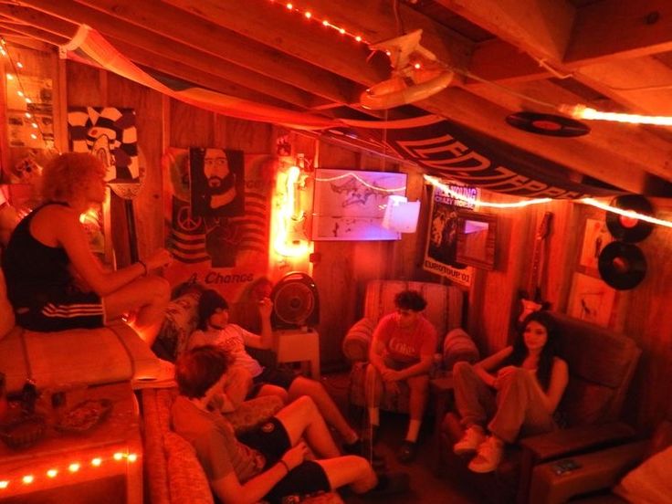 a group of people sitting on couches in a room with lights strung around them