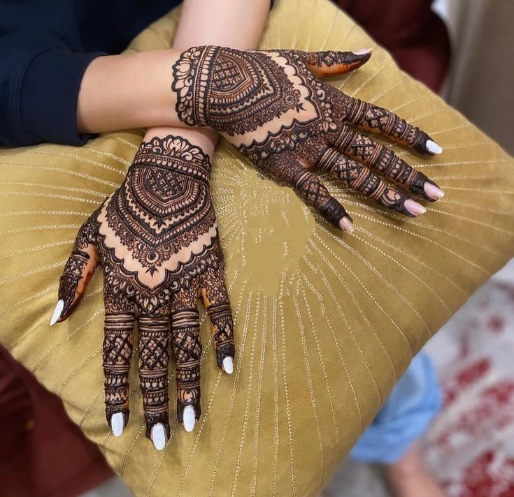 a woman's hands with hennap on her arm and the other hand