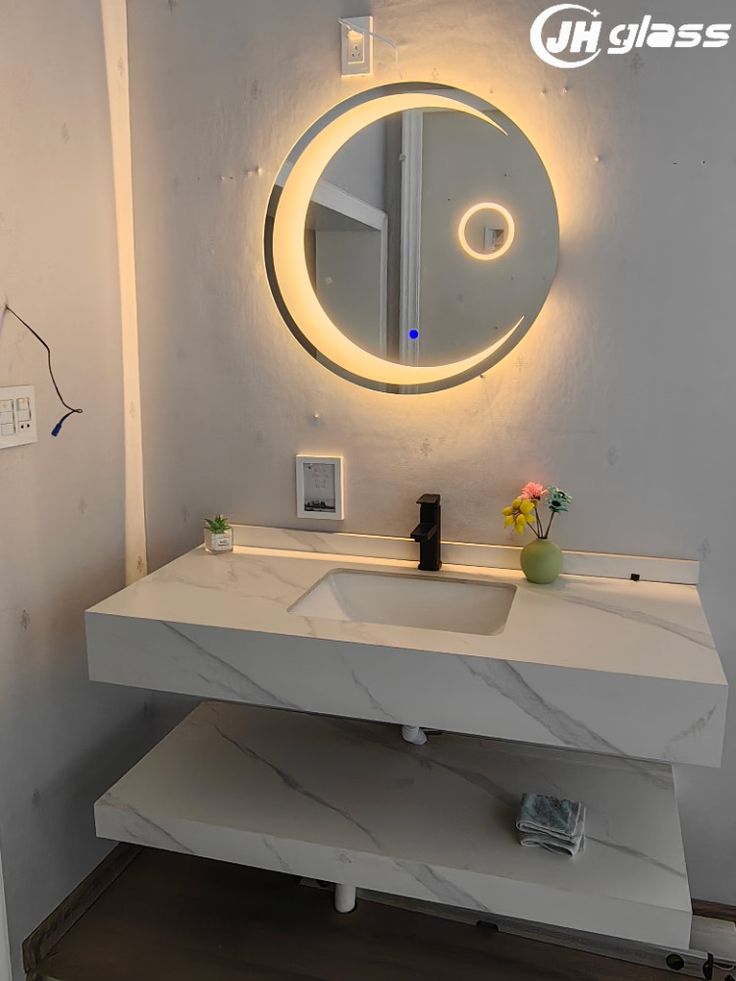 a bathroom vanity with a round mirror above it