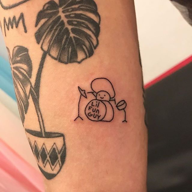 a small tattoo on the arm of a person with a flower and potted plant