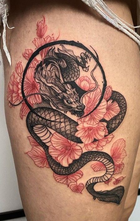 a woman's thigh with a tattoo on it and a snake in the middle