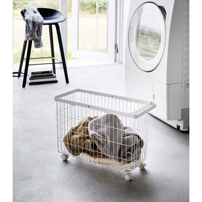 a laundry basket sitting in front of a washer and dryer on the floor