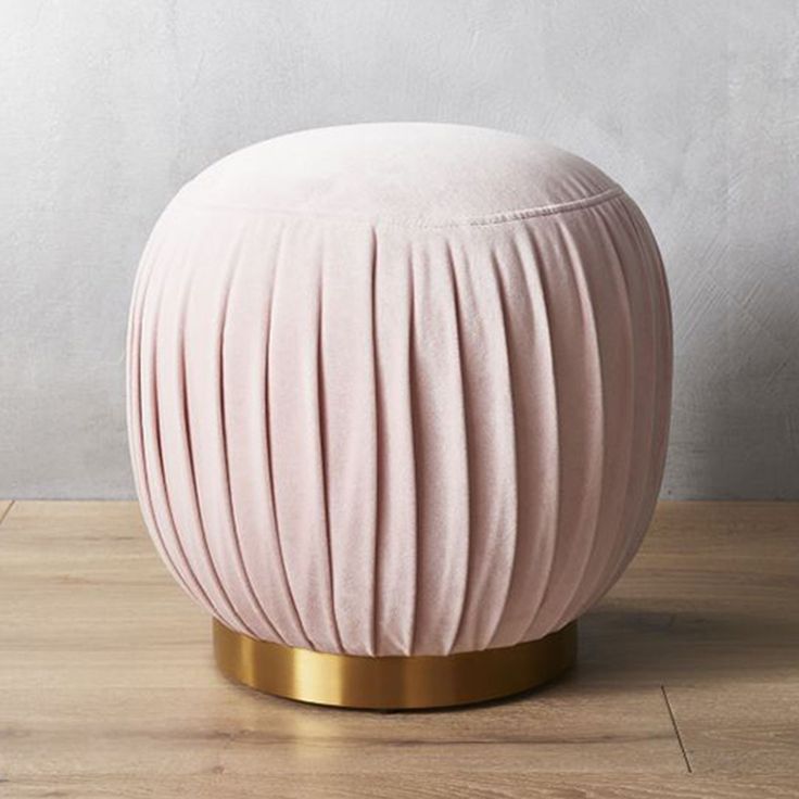 a pink stool sitting on top of a wooden floor