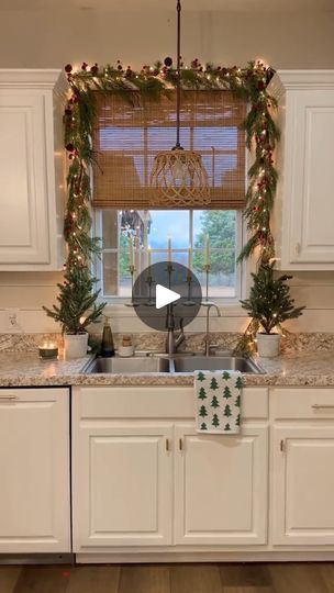 a kitchen decorated for christmas with garland and lights