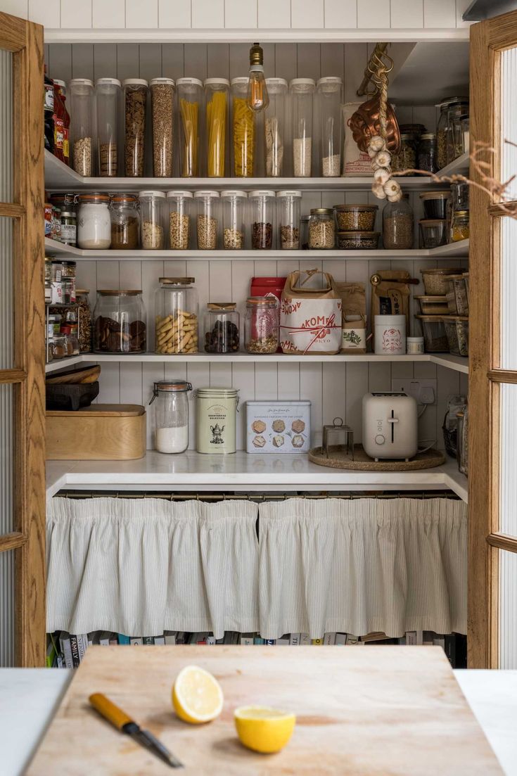 an open pantry with lots of food on the shelves next to a cutting board and knife