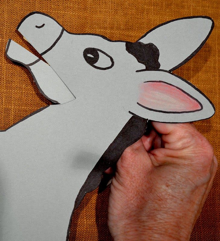 a person cutting out a paper animal with scissors and glue on the back of it