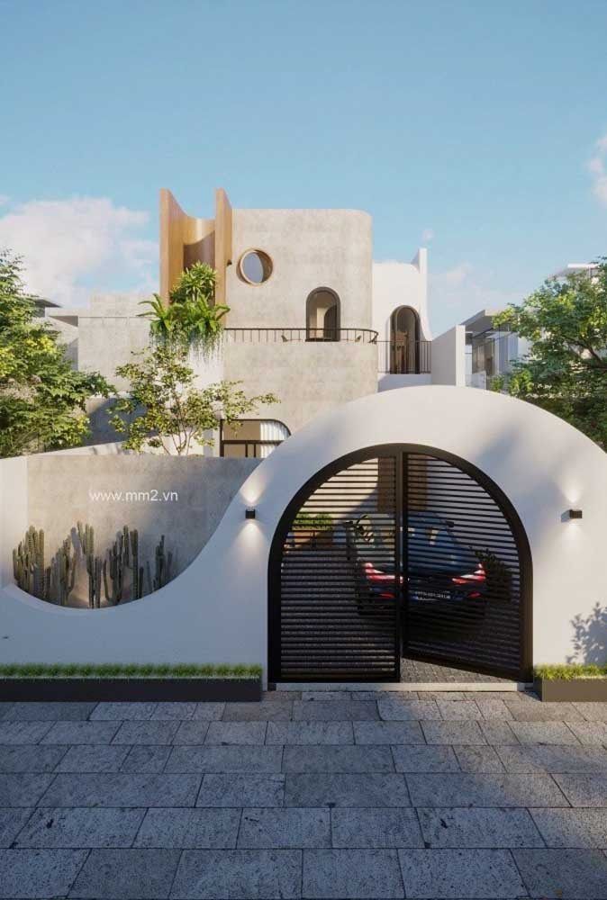 a car is parked in front of a modern building with an arched entrance and brick walkway