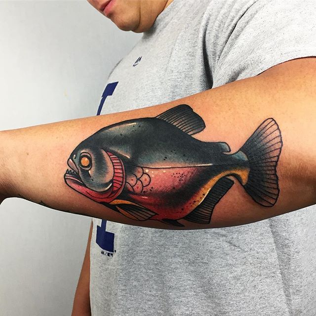 a man with a fish tattoo on his arm