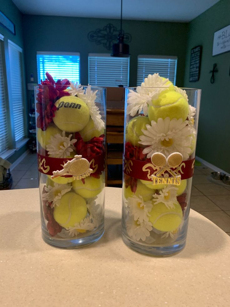 two clear vases filled with yellow and white flowers