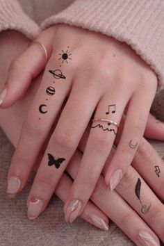 two hands with tattoos on them and one has a butterfly, sun, moon and music notes