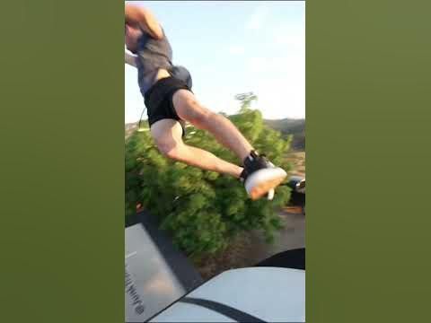 a man in black shorts doing a trick on a skateboard