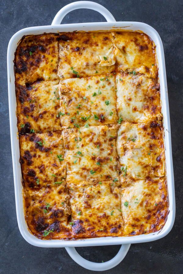 a casserole dish with meat and cheese in it on a gray table top