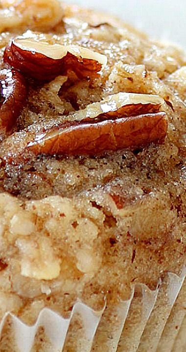 a close up of a muffin with nuts and cinnamon in it on a plate